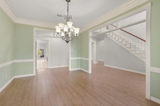 unfurnished dining area featuring a notable chandelier, wood finished floors, visible vents, baseboards, and crown molding