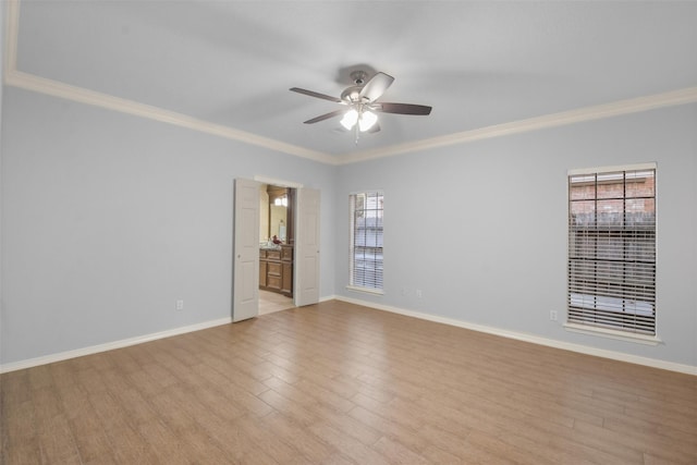 empty room featuring light wood finished floors, ceiling fan, ornamental molding, and baseboards