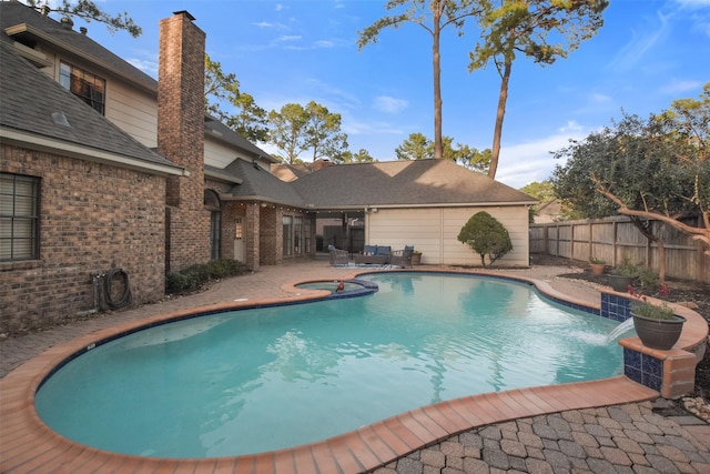 view of swimming pool with a patio area, fence, a fenced in pool, and an in ground hot tub