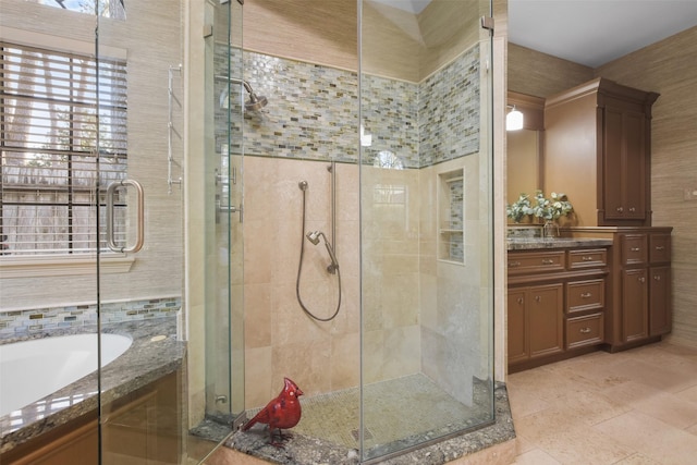 bathroom featuring a stall shower, tile patterned flooring, a garden tub, and vanity