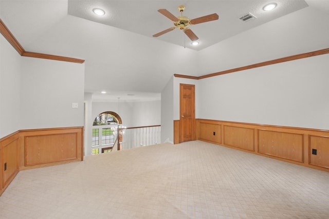 spare room with lofted ceiling, recessed lighting, visible vents, wainscoting, and ceiling fan