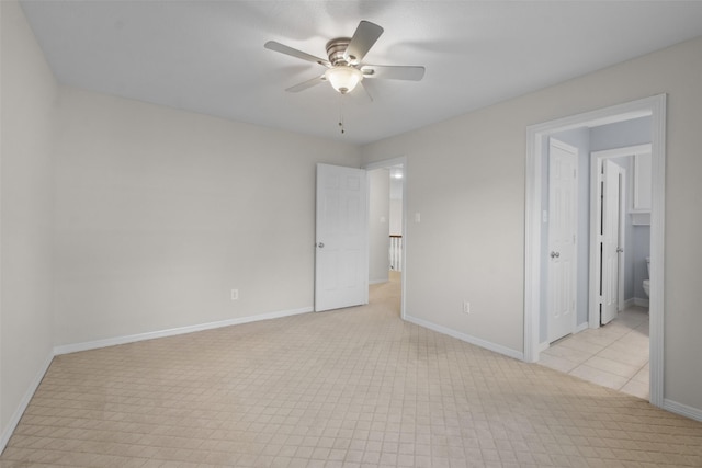 unfurnished room featuring a ceiling fan and baseboards