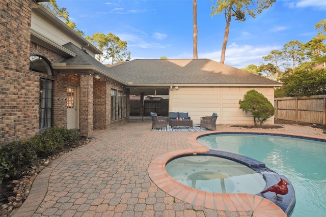 view of pool featuring a pool with connected hot tub, a patio, and fence