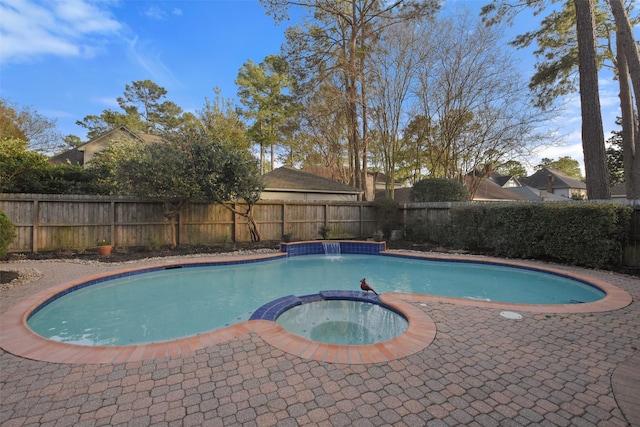 view of swimming pool with a patio, a fenced backyard, and a pool with connected hot tub