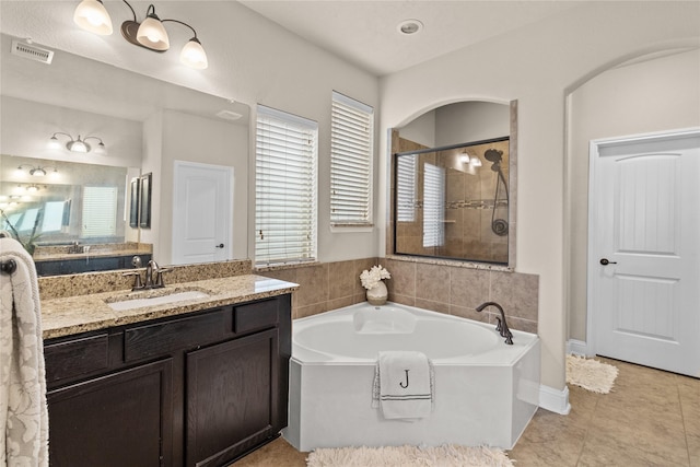 bathroom featuring a wealth of natural light, visible vents, a tile shower, and a bath