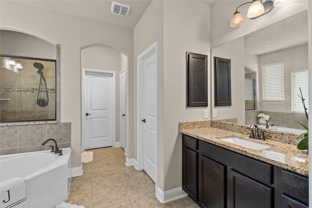 full bathroom featuring tile patterned flooring, a washtub, vanity, visible vents, and tiled shower