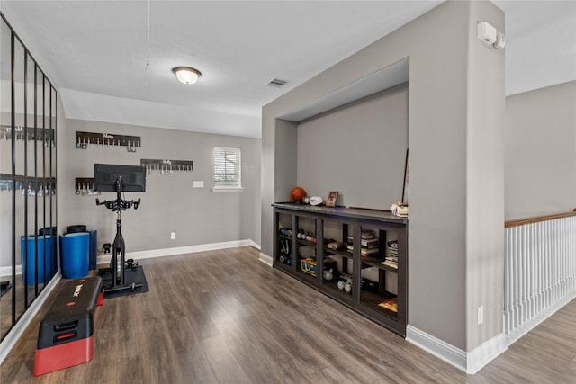 exercise room with visible vents, baseboards, and wood finished floors