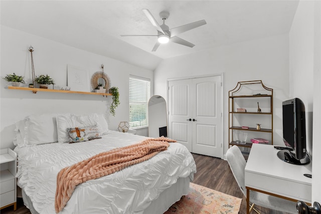 bedroom with vaulted ceiling, a closet, dark wood finished floors, and ceiling fan