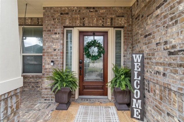 entrance to property featuring brick siding and a porch