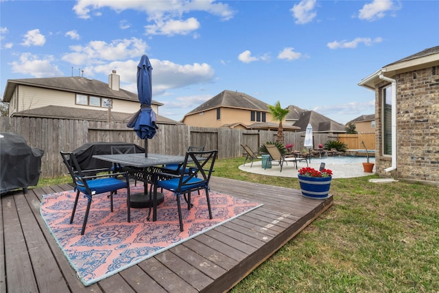 wooden terrace featuring a patio, outdoor dining area, grilling area, and a fenced backyard