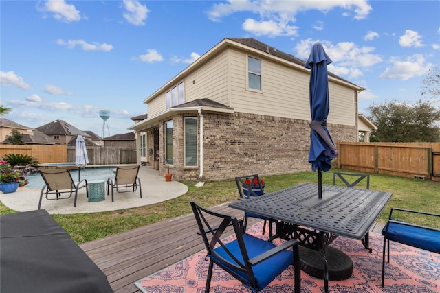 deck with a yard, outdoor dining space, a fenced backyard, and a patio