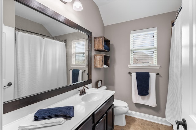 bathroom with toilet, vanity, baseboards, vaulted ceiling, and tile patterned floors