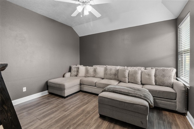 living area featuring vaulted ceiling, ceiling fan, wood finished floors, and baseboards