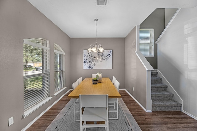 dining space featuring dark wood-type flooring, visible vents, stairway, and baseboards