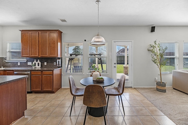 kitchen featuring light tile patterned floors, visible vents, dishwasher, tasteful backsplash, and dark countertops