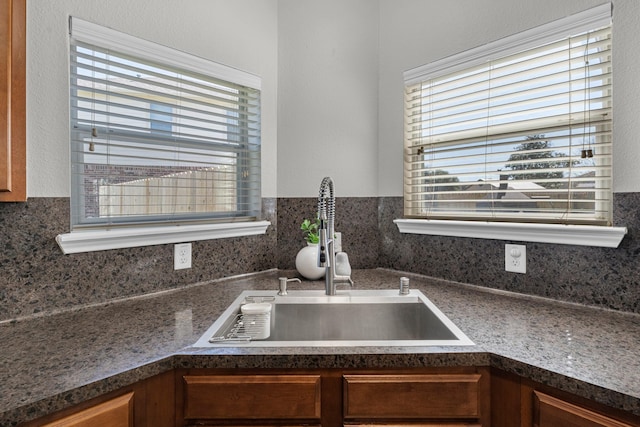 kitchen with dark countertops, brown cabinets, and a sink