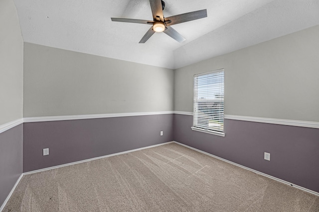 unfurnished room with carpet floors, lofted ceiling, a ceiling fan, a textured ceiling, and baseboards