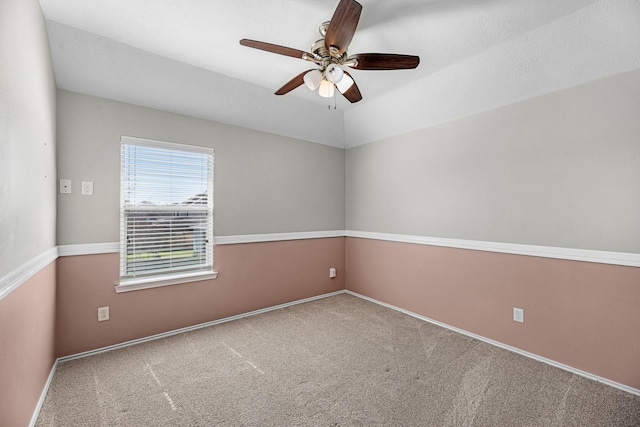 spare room with lofted ceiling, carpet, baseboards, and a ceiling fan