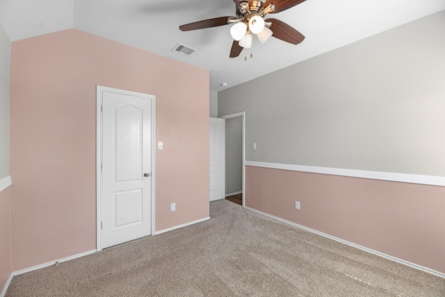 unfurnished bedroom featuring visible vents, baseboards, ceiling fan, vaulted ceiling, and carpet floors