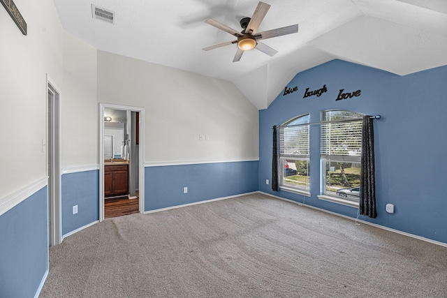 unfurnished room with visible vents, baseboards, ceiling fan, vaulted ceiling, and carpet floors