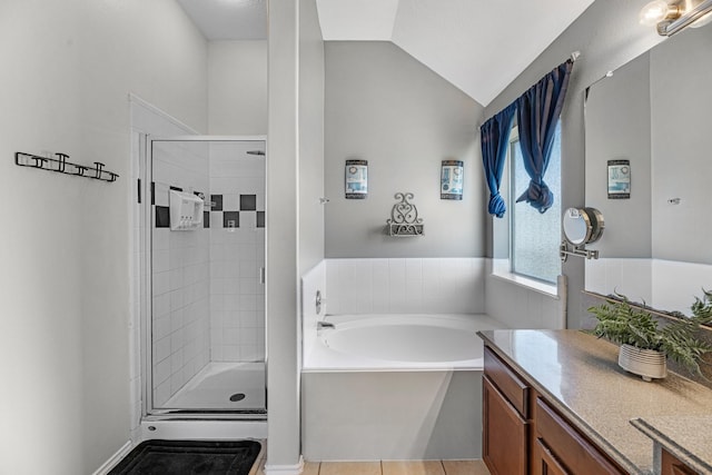 bathroom with a garden tub, lofted ceiling, a shower stall, vanity, and tile patterned flooring