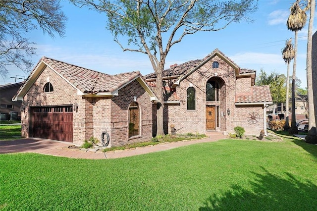 view of front of home with a garage, aphalt driveway, a tiled roof, a front yard, and brick siding