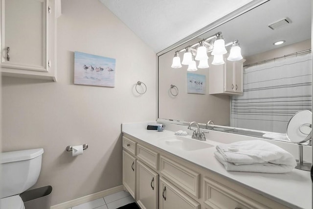 bathroom featuring tile patterned flooring, toilet, vanity, baseboards, and vaulted ceiling