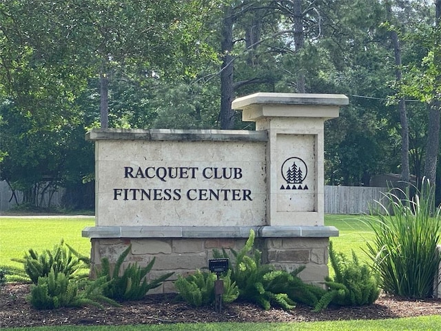 community / neighborhood sign with fence and a yard