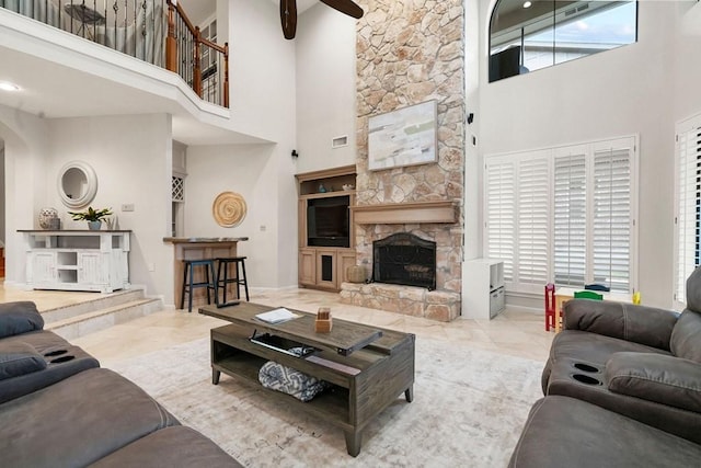 living area with visible vents and a stone fireplace