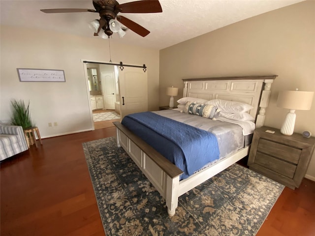 bedroom featuring a ceiling fan, wood finished floors, baseboards, and a barn door