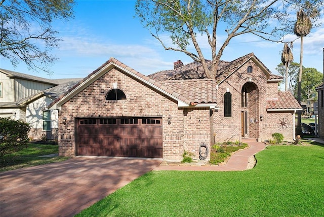 view of front facade with a chimney, an attached garage, driveway, a tiled roof, and a front lawn