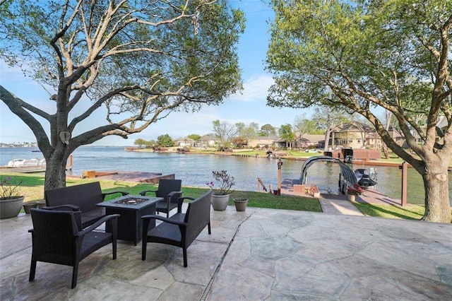 view of patio with an outdoor fire pit and a water view