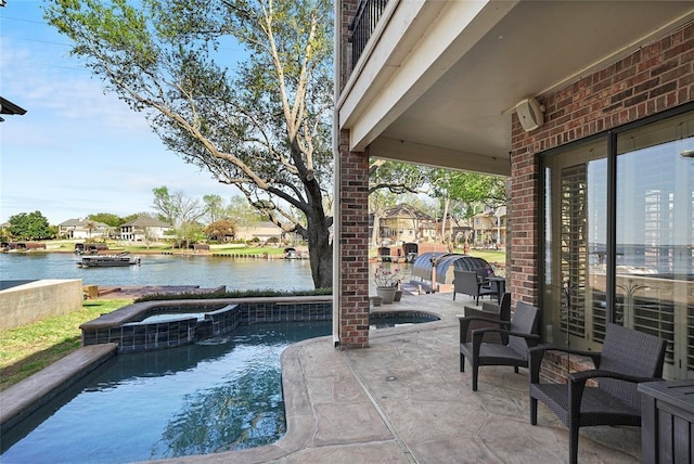 view of patio with a water view and a pool with connected hot tub