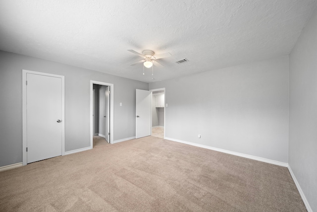 unfurnished bedroom with ceiling fan, carpet flooring, visible vents, and baseboards