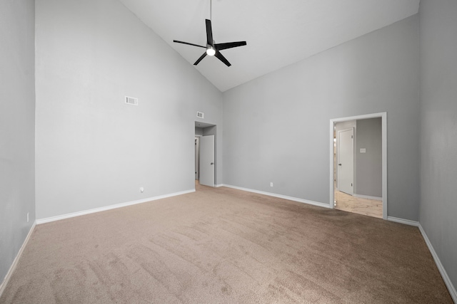 spare room with ceiling fan, high vaulted ceiling, carpet floors, visible vents, and baseboards