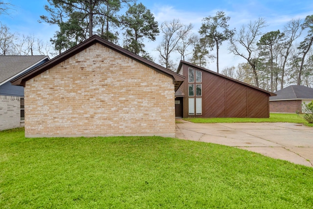 view of side of home with a yard and brick siding