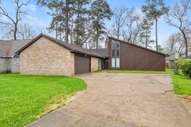 mid-century home featuring a garage, brick siding, driveway, a front lawn, and a chimney