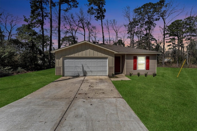 view of front facade with driveway, a lawn, an attached garage, and board and batten siding