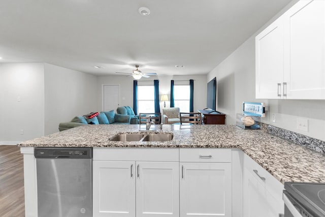 kitchen featuring stainless steel appliances, a peninsula, a sink, white cabinets, and open floor plan