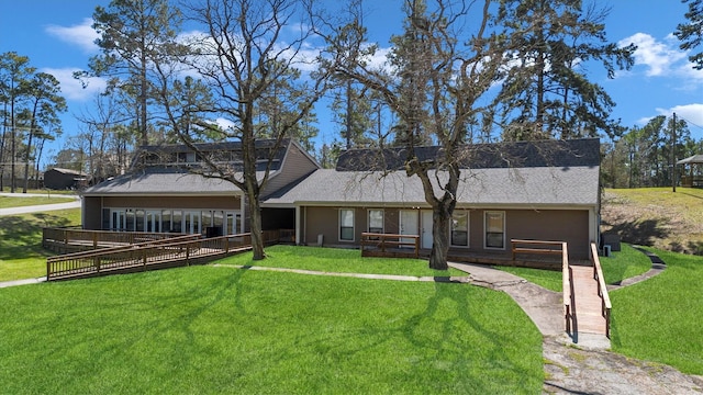 rear view of house featuring a deck and a yard