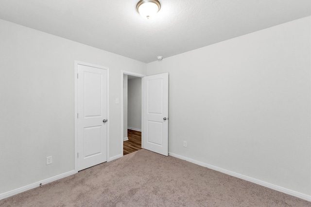 carpeted empty room featuring baseboards