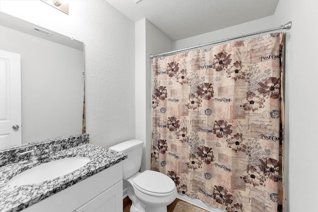 bathroom with visible vents, a textured wall, toilet, a shower with shower curtain, and vanity