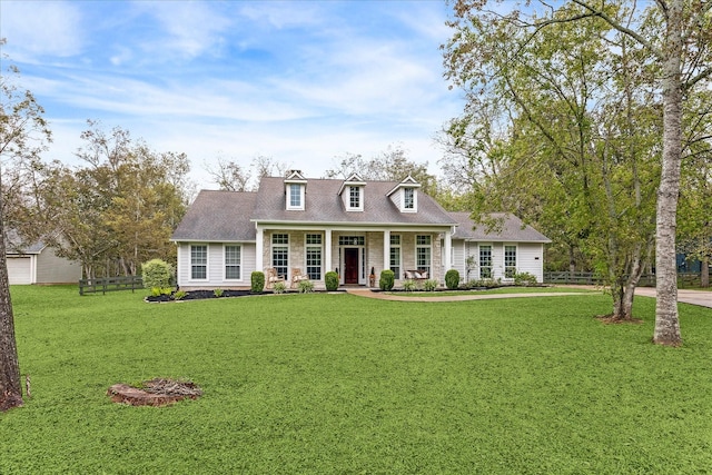 cape cod home with stone siding, a porch, fence, and a front lawn