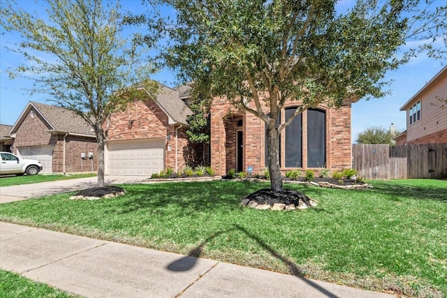 view of front of home featuring brick siding, fence, a front yard, and a garage