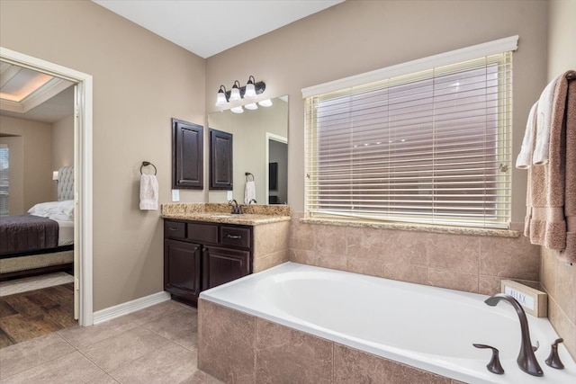 full bath featuring a bath, baseboards, connected bathroom, tile patterned floors, and vanity