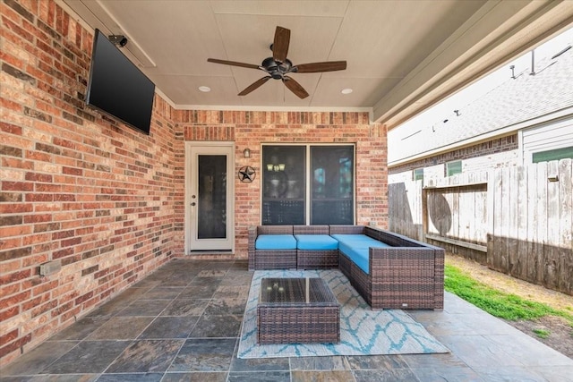 view of patio / terrace with an outdoor living space, fence, and a ceiling fan