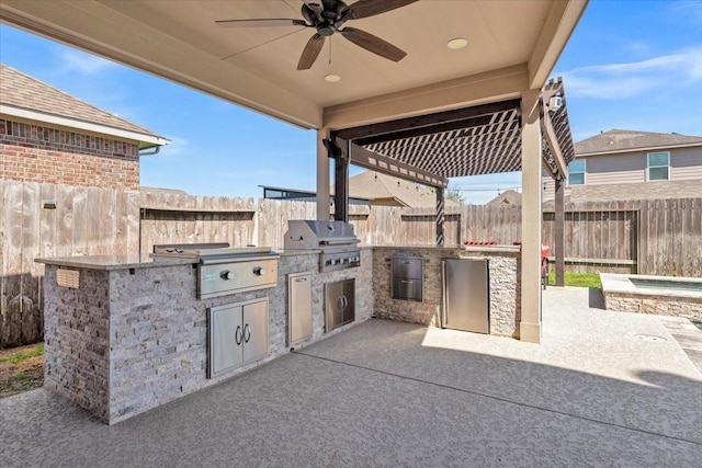 view of patio with a fenced backyard, an outdoor kitchen, and area for grilling