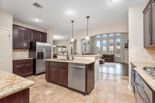 kitchen with visible vents, a sink, a wealth of natural light, stone tile flooring, and appliances with stainless steel finishes