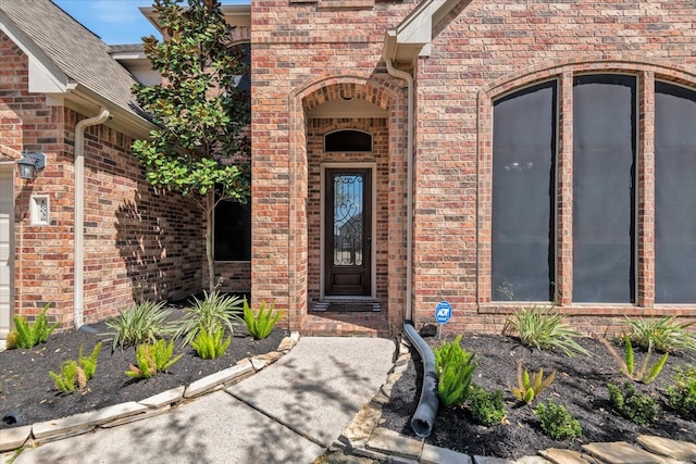 entrance to property featuring brick siding