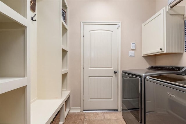 clothes washing area with independent washer and dryer and cabinet space